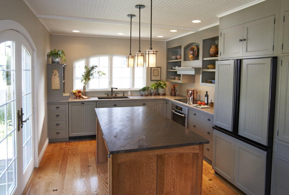 Foto de cocinas en L clásica cerrada con fregadero de doble seno, puertas de armario grises y electrodomésticos con paneles