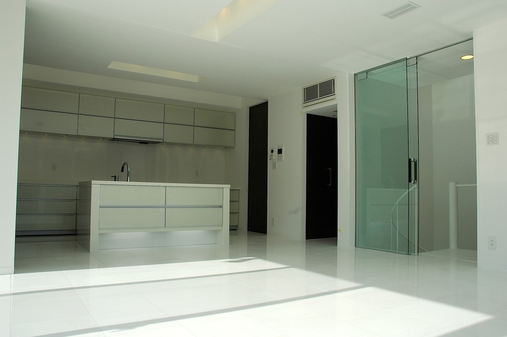 Foto på ett funkis kök, med en undermonterad diskho, släta luckor, vita skåp, bänkskiva i koppar, vitt stänkskydd, glaspanel som stänkskydd, integrerade vitvaror, marmorgolv, en köksö och vitt golv