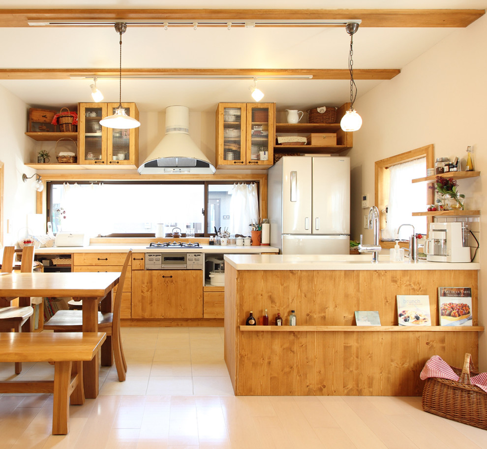 На фото: кухня в стиле лофт с обеденным столом, плоскими фасадами, светлыми деревянными фасадами, белой техникой, полуостровом и окном с