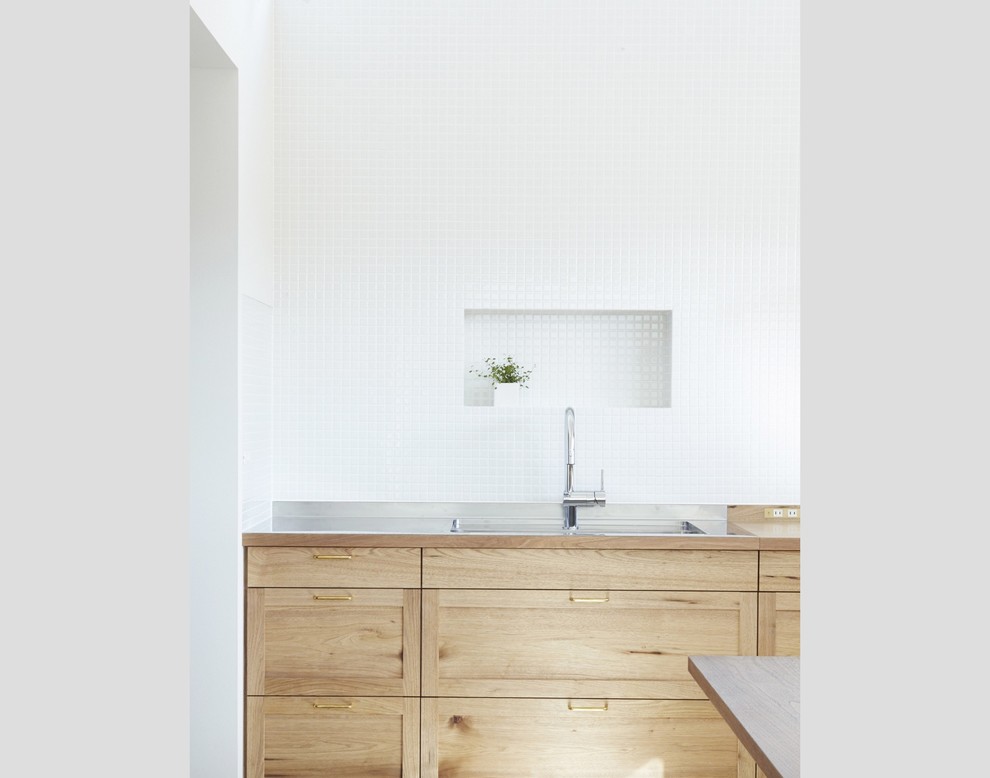 Example of a minimalist light wood floor kitchen design in Other with medium tone wood cabinets and wood backsplash