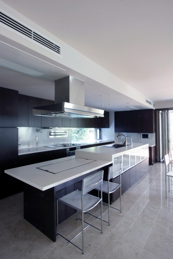 Diseño de cocina contemporánea con fregadero de un seno, armarios con paneles lisos, puertas de armario negras, una isla y suelo beige