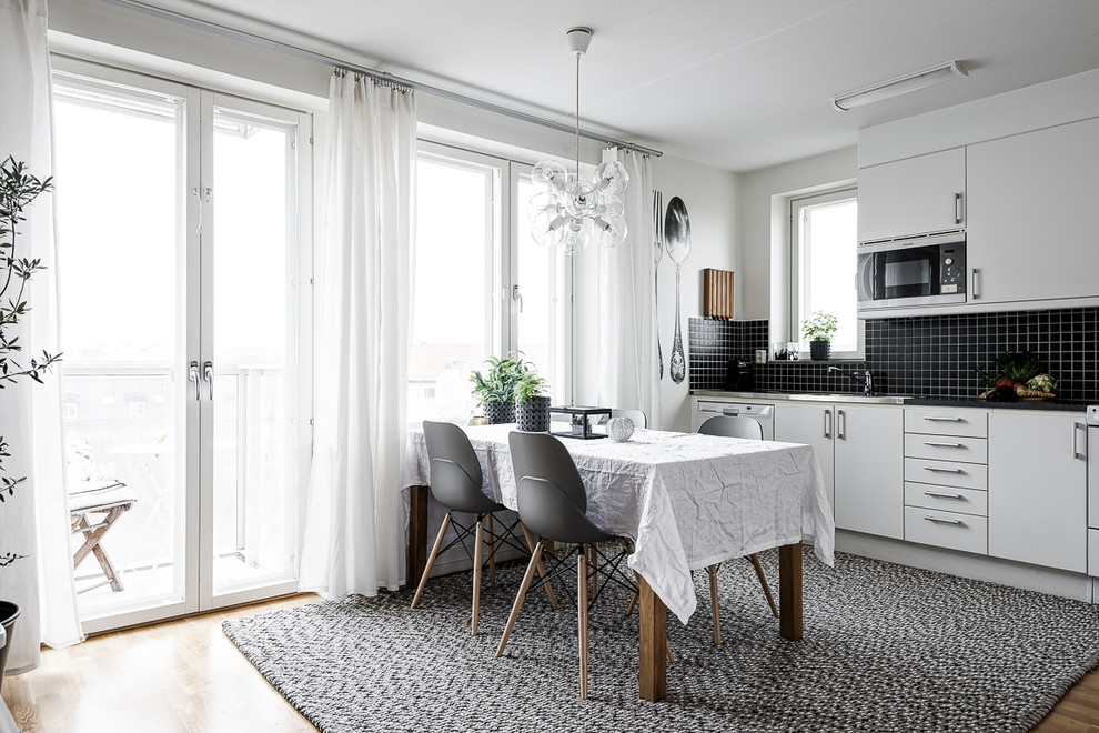 Einzeilige, Mittelgroße Nordische Küche ohne Insel mit flächenbündigen Schrankfronten, weißen Schränken, Küchenrückwand in Weiß, Rückwand aus Porzellanfliesen und braunem Holzboden in Stockholm
