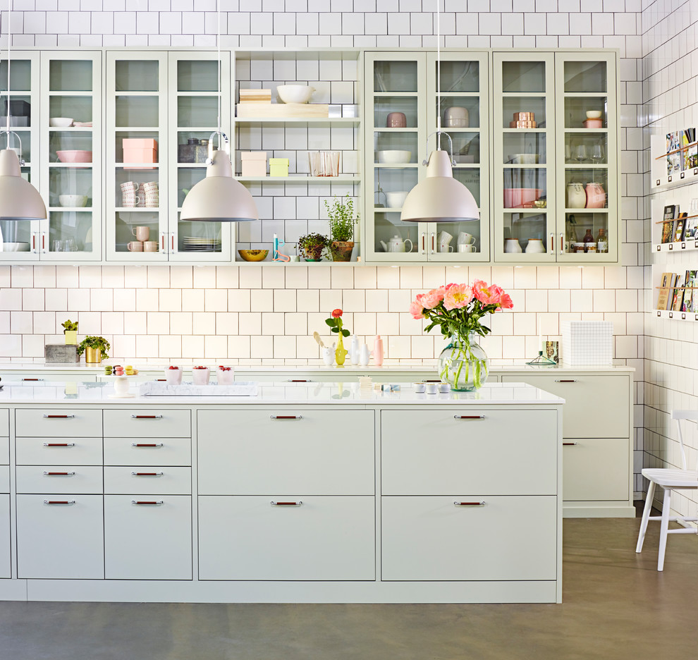 Zweizeilige Skandinavische Küche mit flächenbündigen Schrankfronten, grünen Schränken, Küchenrückwand in Weiß, Betonboden und Kücheninsel in Malmö