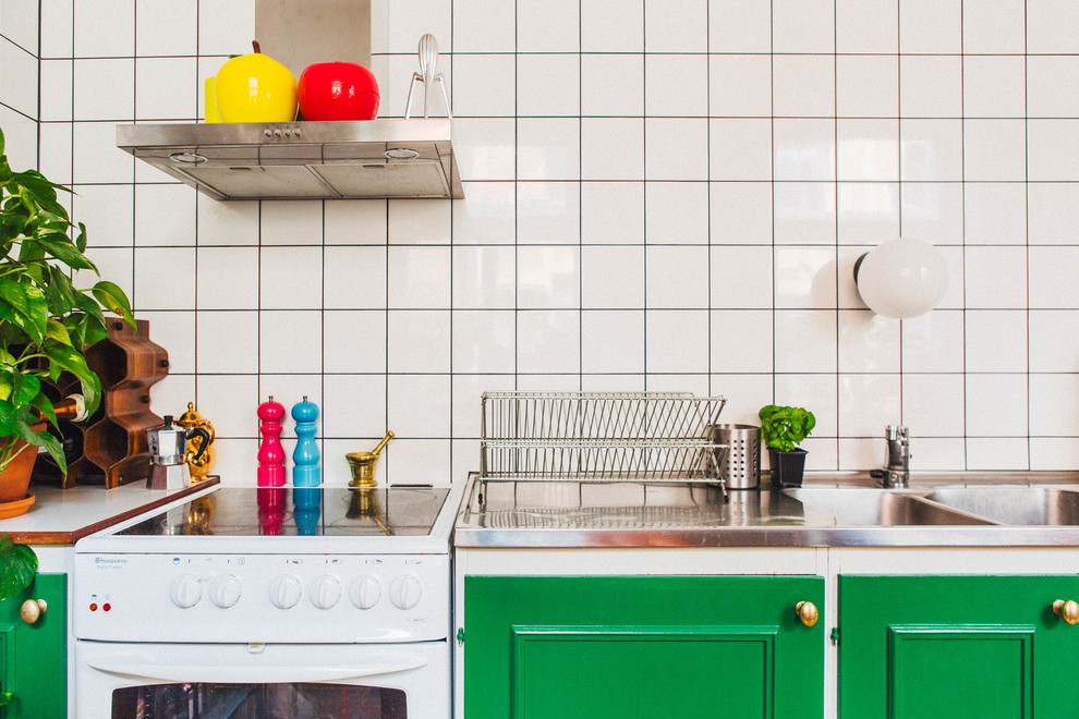 Small danish single-wall kitchen photo in Stockholm with a double-bowl sink, stainless steel countertops, white backsplash, porcelain backsplash and white appliances