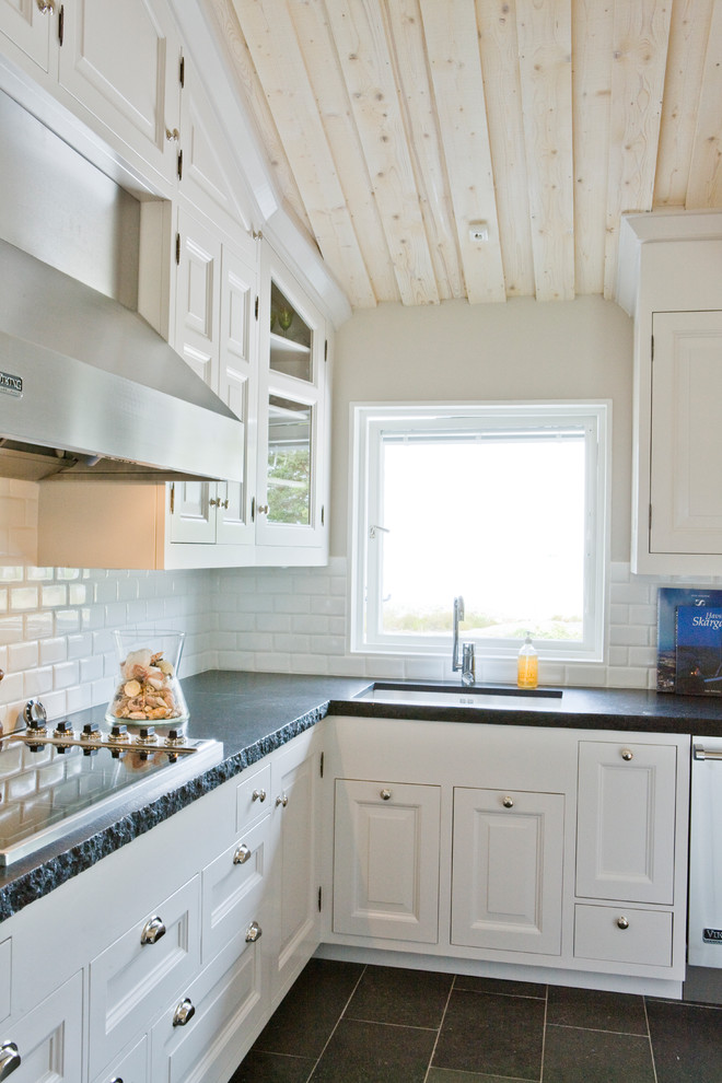 Inspiration för ett mellanstort vintage kök, med en undermonterad diskho, vita skåp, granitbänkskiva, vitt stänkskydd, stänkskydd i keramik, rostfria vitvaror, skiffergolv, en köksö, grått golv och luckor med upphöjd panel