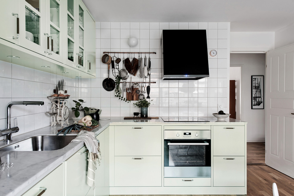 Große Skandinavische Küche ohne Insel in L-Form mit Waschbecken, flächenbündigen Schrankfronten, weißen Schränken, Marmor-Arbeitsplatte, Küchenrückwand in Weiß und dunklem Holzboden in Göteborg