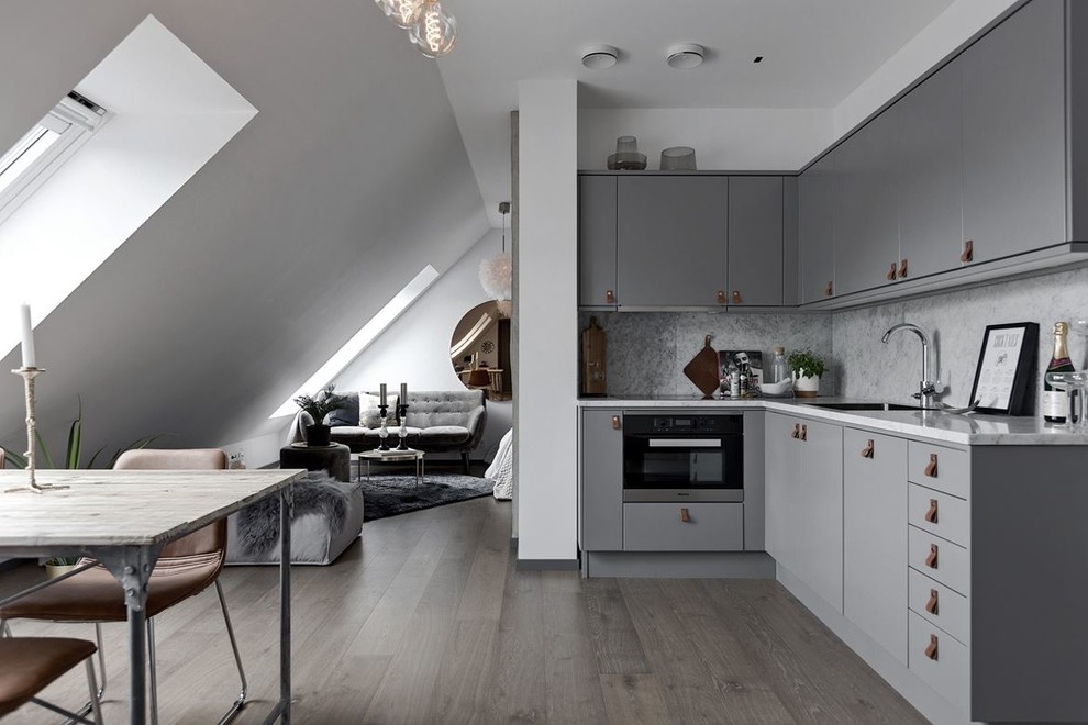 Danish l-shaped open concept kitchen photo in Stockholm with flat-panel cabinets, gray cabinets, marble countertops and no island