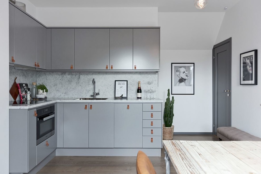 Inspiration för avskilda, små minimalistiska l-kök, med släta luckor, grå skåp, marmorbänkskiva och grått stänkskydd