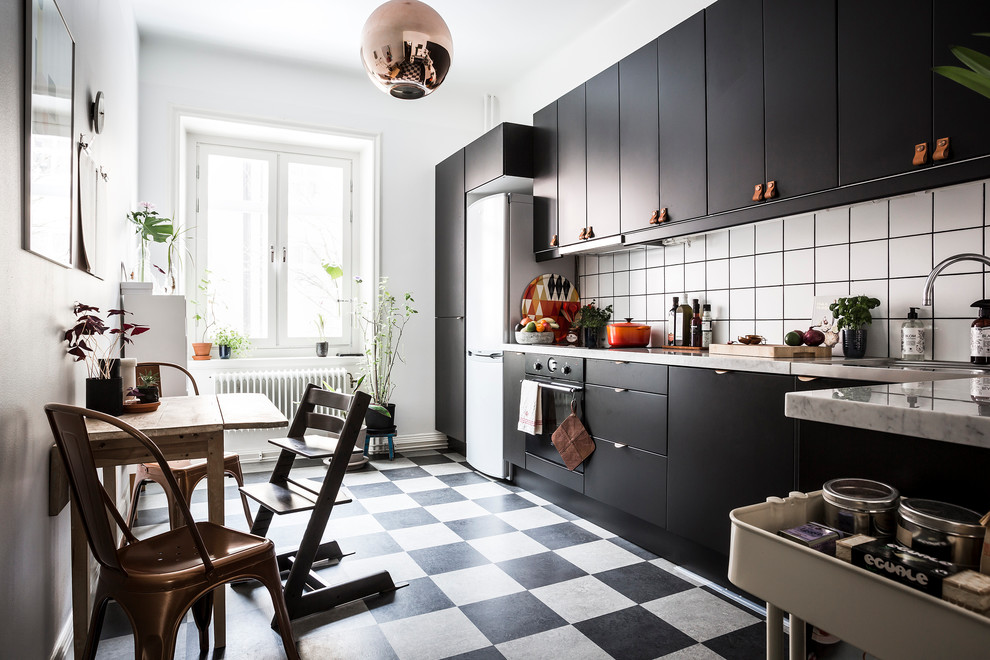 Пример оригинального дизайна: прямая кухня среднего размера в скандинавском стиле с плоскими фасадами, черными фасадами, белым фартуком, одинарной мойкой и полом из керамической плитки без острова