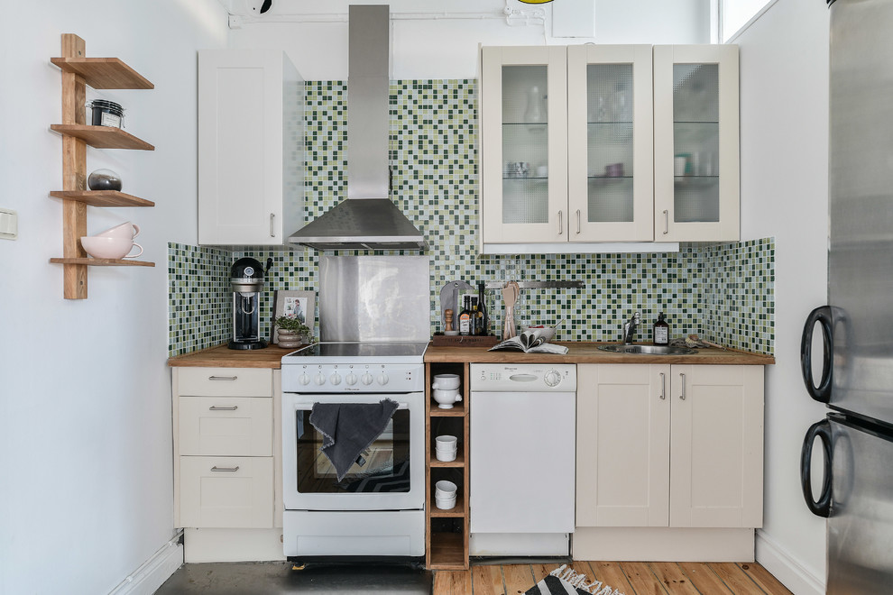 Photo of a contemporary single-wall enclosed kitchen in Stockholm with a built-in sink, shaker cabinets, beige cabinets, wood worktops, multi-coloured splashback, stainless steel appliances, medium hardwood flooring, brown floors, brown worktops and mosaic tiled splashback.