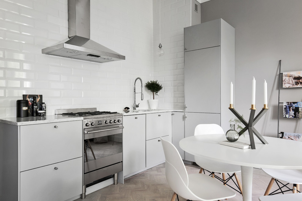 Photo of a medium sized scandinavian single-wall kitchen/diner in Stockholm with flat-panel cabinets, grey cabinets, marble worktops, stainless steel appliances, light hardwood flooring and no island.