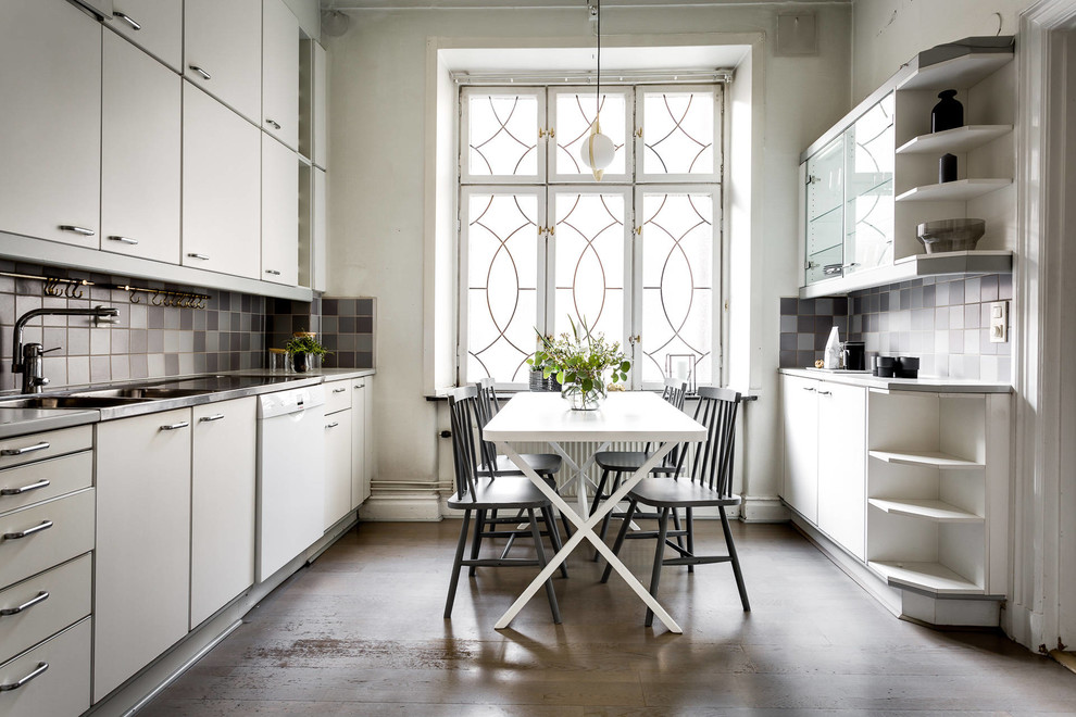 Foto på ett stort skandinaviskt kök och matrum, med en dubbel diskho, släta luckor, vita skåp, flerfärgad stänkskydd och stänkskydd i mosaik