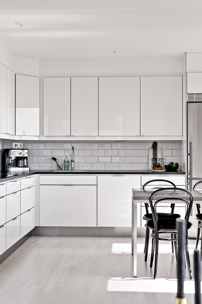 Mittelgroße Skandinavische Küche in L-Form mit weißen Schränken und weißen Elektrogeräten in Stockholm