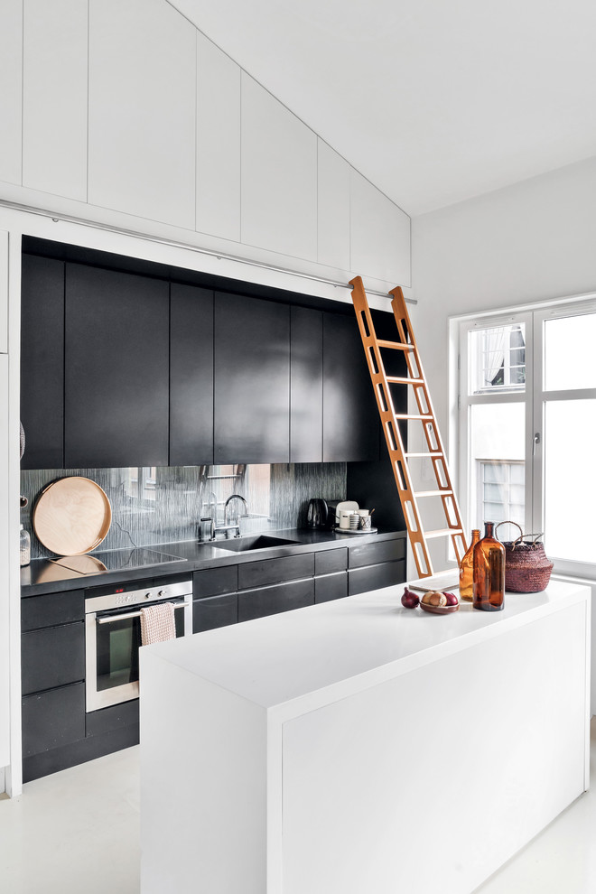 Zweizeilige Moderne Küche mit flächenbündigen Schrankfronten, schwarzen Schränken, Küchenrückwand in Grau, Küchengeräten aus Edelstahl, Kücheninsel, grauem Boden und grauer Arbeitsplatte in Stockholm