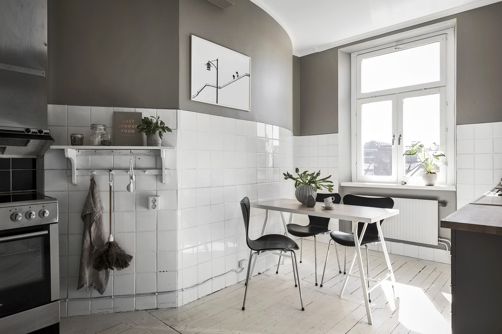 Inredning av ett industriellt mellanstort kök och matrum, med målat trägolv och vitt golv