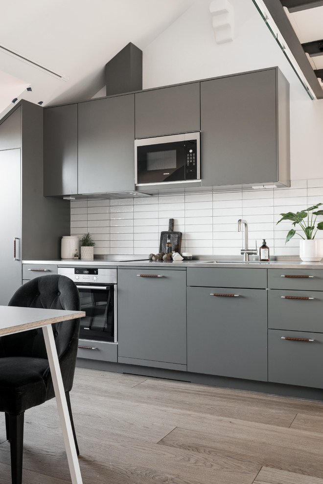 Photo of a scandinavian kitchen in Stockholm with grey cabinets.