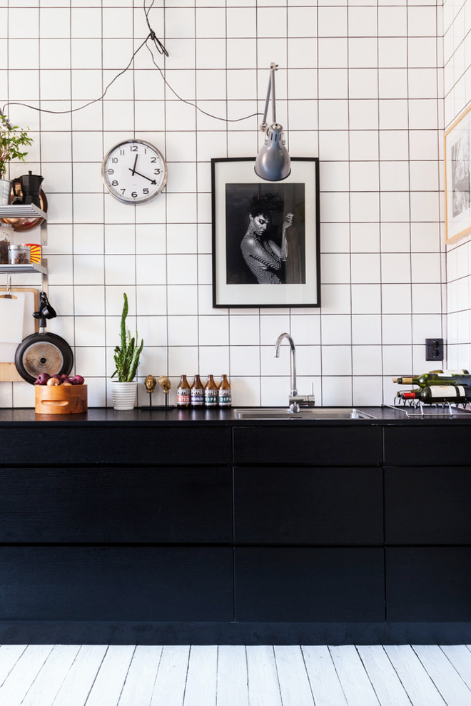 Einzeilige Industrial Küche mit flächenbündigen Schrankfronten und schwarzen Schränken in Göteborg