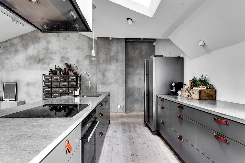 Foto på ett industriellt linjärt kök med öppen planlösning, med släta luckor, grå skåp, bänkskiva i betong, ljust trägolv, en köksö och grått golv