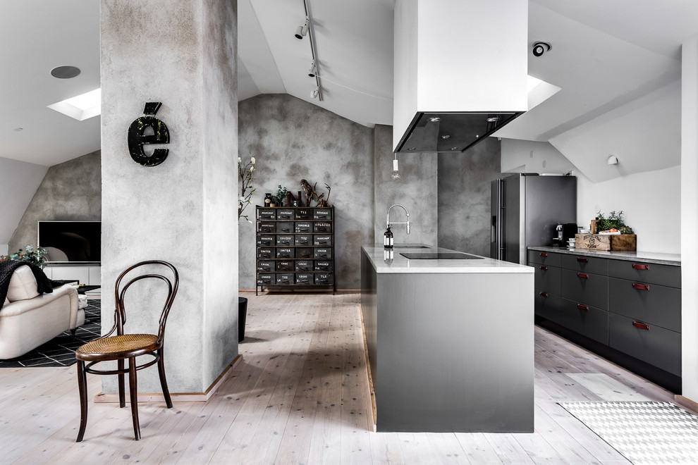Expansive industrial kitchen in Stockholm with light hardwood flooring.