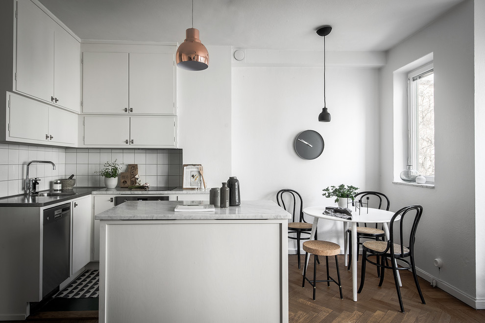 Kleine Nordische Wohnküche in L-Form mit integriertem Waschbecken, flächenbündigen Schrankfronten, weißen Schränken, Küchenrückwand in Weiß, Küchengeräten aus Edelstahl, dunklem Holzboden, Kücheninsel und Marmor-Arbeitsplatte in Stockholm