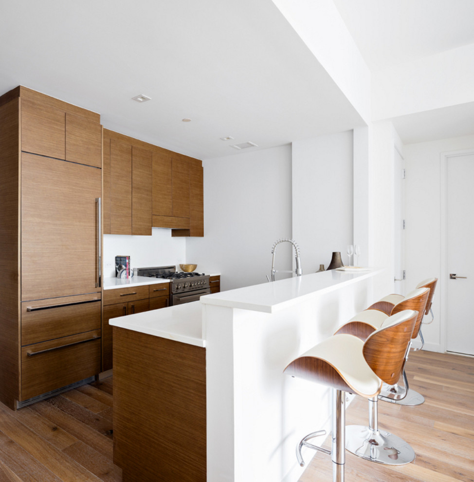 Aménagement d'une cuisine parallèle rétro en bois foncé avec un placard à porte plane, un plan de travail en stratifié et un sol en bois brun.