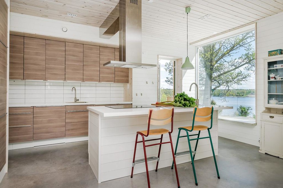 Modern inredning av ett stort linjärt kök, med släta luckor, skåp i mellenmörkt trä, vitt stänkskydd, integrerade vitvaror, betonggolv, en köksö och grått golv
