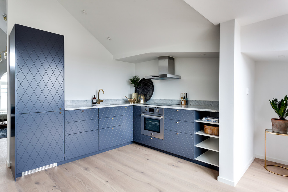 Mittelgroße Nordische Küche ohne Insel in L-Form mit Waschbecken, blauen Schränken, Küchengeräten aus Edelstahl, hellem Holzboden und Marmor-Arbeitsplatte in Stockholm