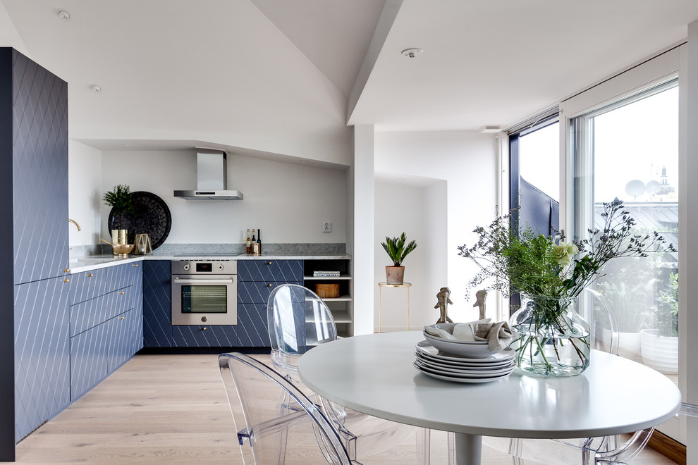 Foto på ett litet minimalistiskt l-kök, med blå skåp