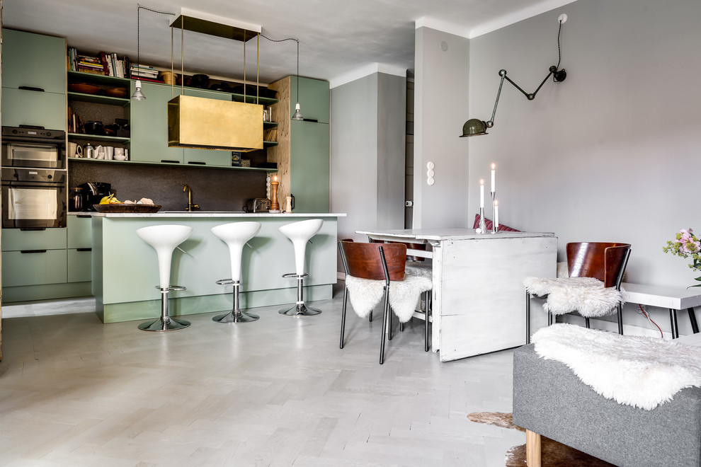 На фото: кухня-гостиная среднего размера в скандинавском стиле с плоскими фасадами, серым фартуком, островом и белым полом