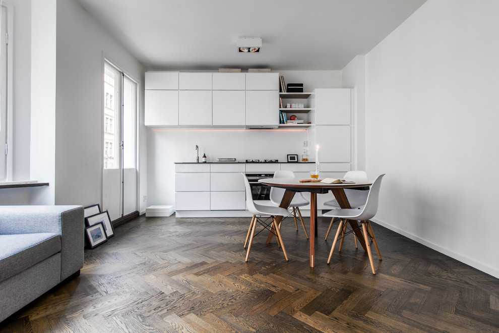 Exempel på ett mellanstort minimalistiskt linjärt kök och matrum, med släta luckor, vita skåp, laminatbänkskiva och mörkt trägolv
