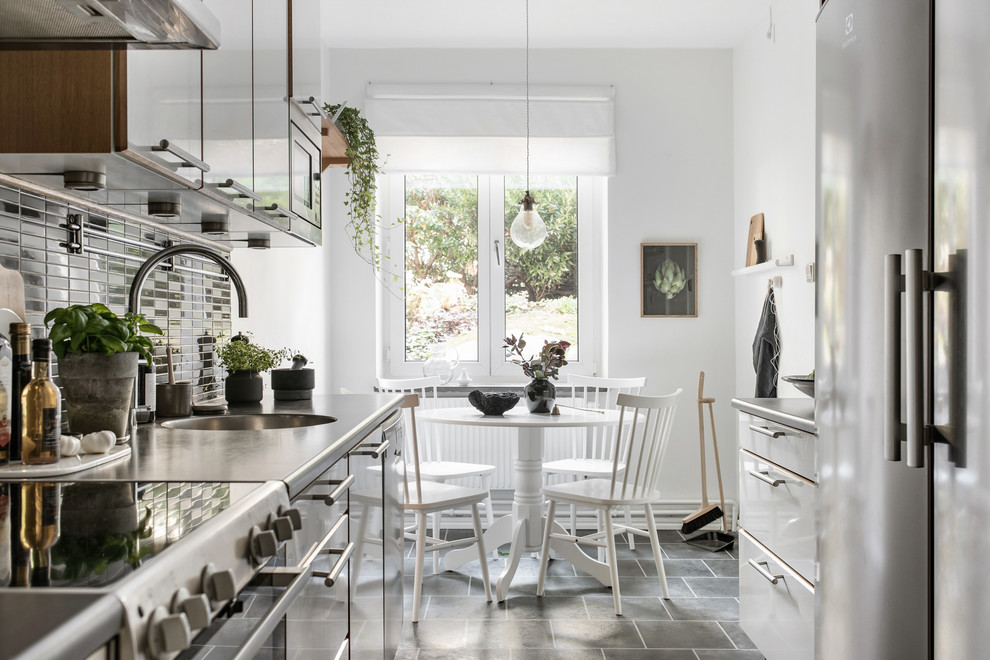 Inspiration för nordiska grått kök, med släta luckor, vita skåp, rostfria vitvaror och grått golv