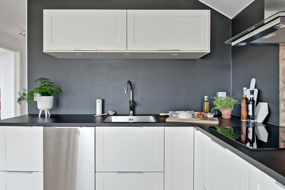Inspiration for a scandi l-shaped kitchen in Gothenburg with a built-in sink, shaker cabinets, white cabinets, stainless steel appliances, no island and granite worktops.
