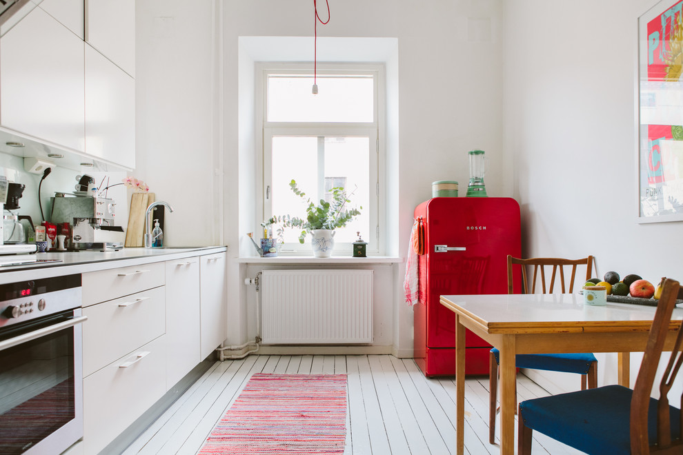 Imagen de cocina lineal escandinava grande cerrada sin isla con armarios con paneles lisos, puertas de armario blancas, encimera de madera, electrodomésticos blancos y suelo de madera pintada