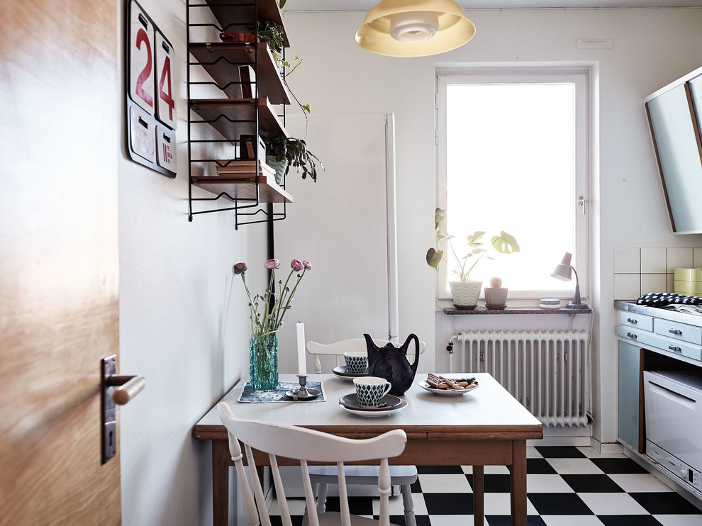 Imagen de cocina comedor lineal escandinava pequeña sin isla con armarios con paneles lisos, puertas de armario azules y suelo de baldosas de cerámica