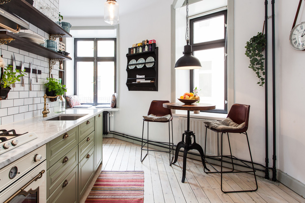Inspiration for a mid-sized scandinavian single-wall light wood floor eat-in kitchen remodel in Stockholm with an undermount sink, raised-panel cabinets, green cabinets, white backsplash, subway tile backsplash, white appliances and no island