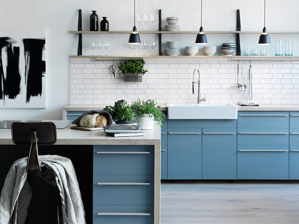Kitchen - large scandinavian galley light wood floor and beige floor kitchen idea in Malmo with wood countertops, an island, a farmhouse sink, flat-panel cabinets, blue cabinets, white backsplash, ceramic backsplash, paneled appliances and beige countertops