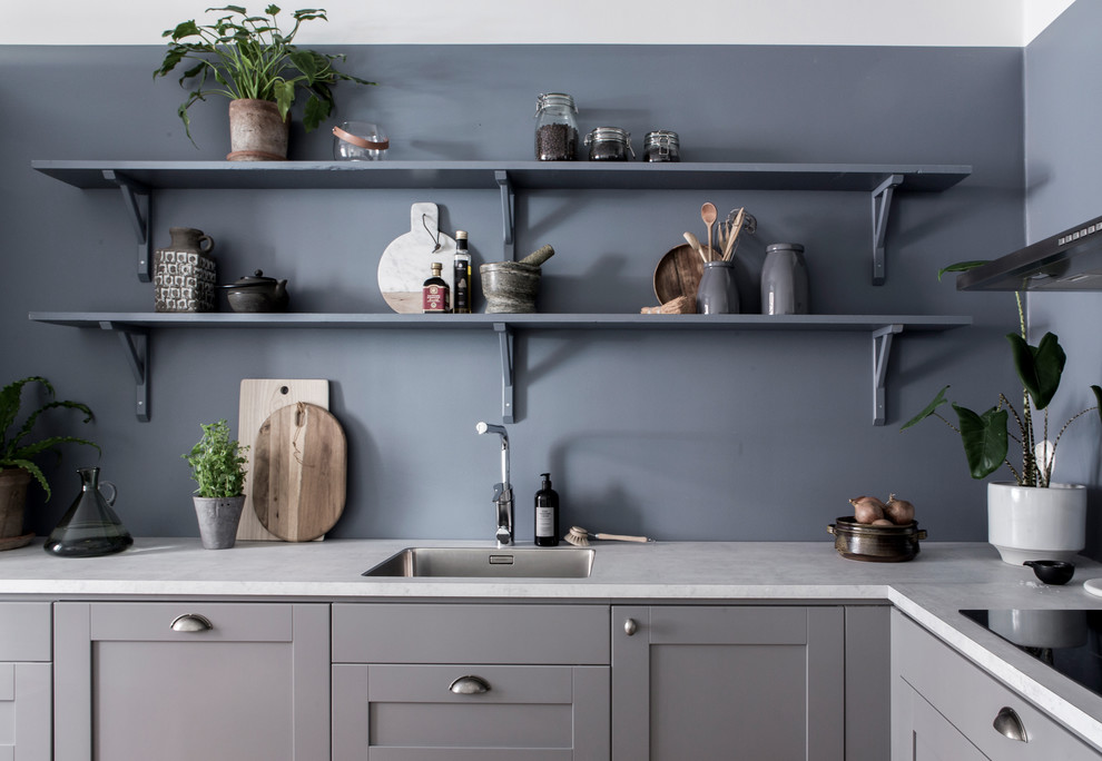 Klassische Küche mit Einbauwaschbecken, Schrankfronten im Shaker-Stil, grauen Schränken, Küchengeräten aus Edelstahl und weißer Arbeitsplatte in Göteborg