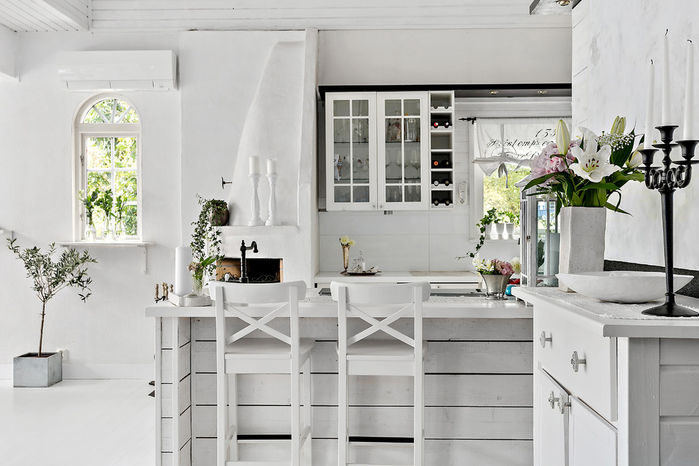 Пример оригинального дизайна: кухня в стиле шебби-шик с стеклянными фасадами, белыми фасадами, белым фартуком, деревянным полом и полуостровом