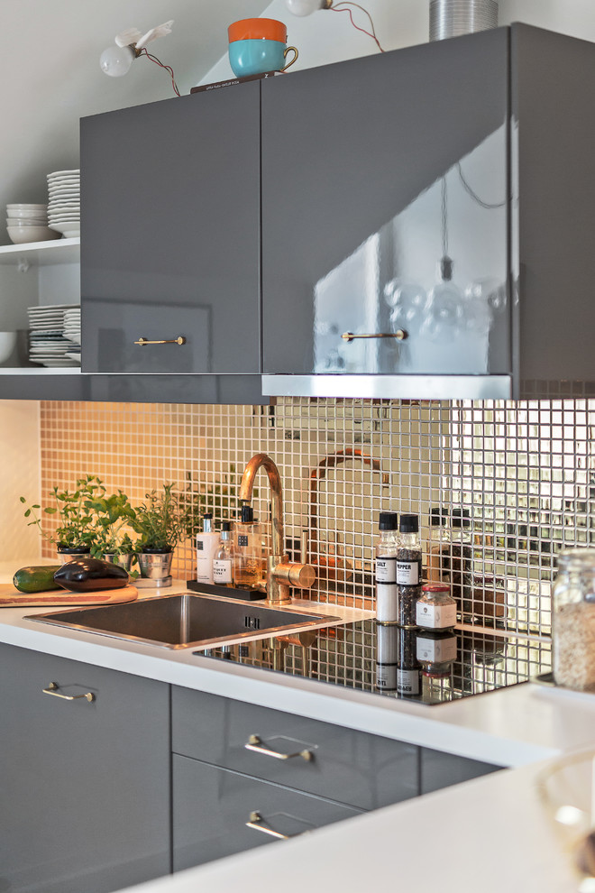 Klassische Küche in L-Form mit Einbauwaschbecken, flächenbündigen Schrankfronten, grauen Schränken und Küchenrückwand in Metallic in Stockholm