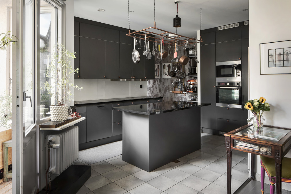 Photo of a scandinavian l-shaped kitchen in Stockholm with flat-panel cabinets, grey cabinets, stainless steel appliances, an island and grey floors.