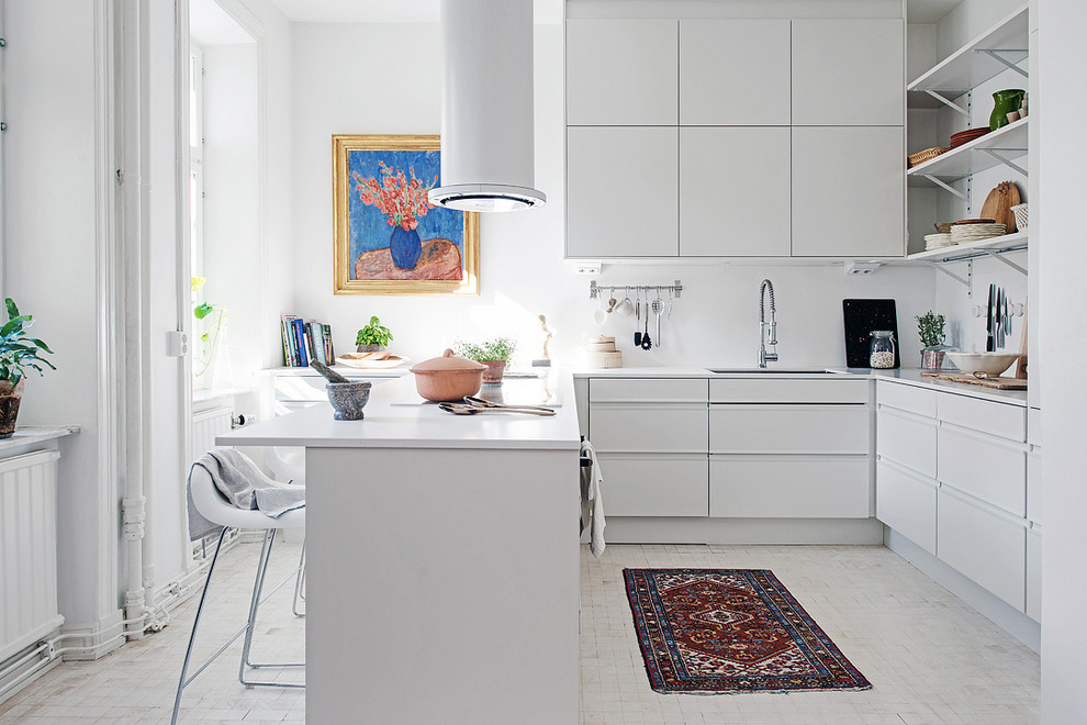 Exempel på ett stort skandinaviskt u-kök, med en undermonterad diskho, släta luckor, vita skåp, en halv köksö, vita vitvaror och ljust trägolv