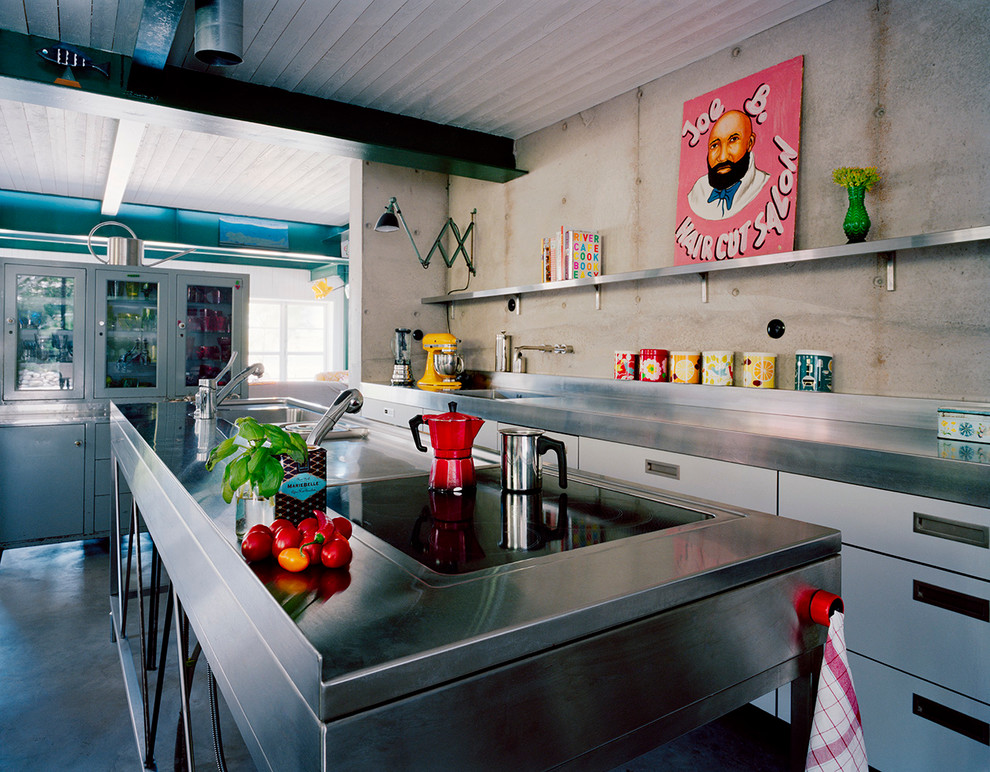 На фото: прямая кухня среднего размера в стиле лофт с одинарной мойкой, плоскими фасадами, белыми фасадами, столешницей из нержавеющей стали, бетонным полом и островом