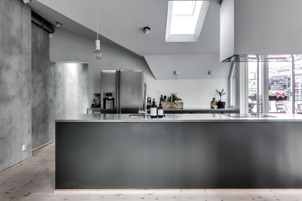 Foto på ett mellanstort industriellt kök, med en enkel diskho, marmorbänkskiva, rostfria vitvaror, ljust trägolv och en köksö