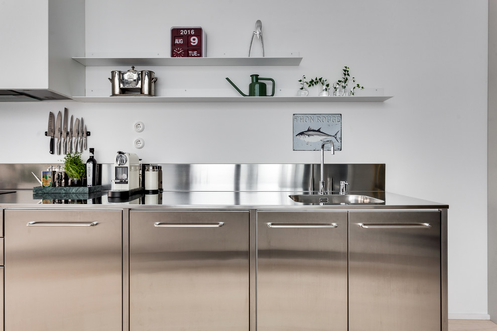Photo of an urban kitchen in Stockholm with a built-in sink and stainless steel worktops.