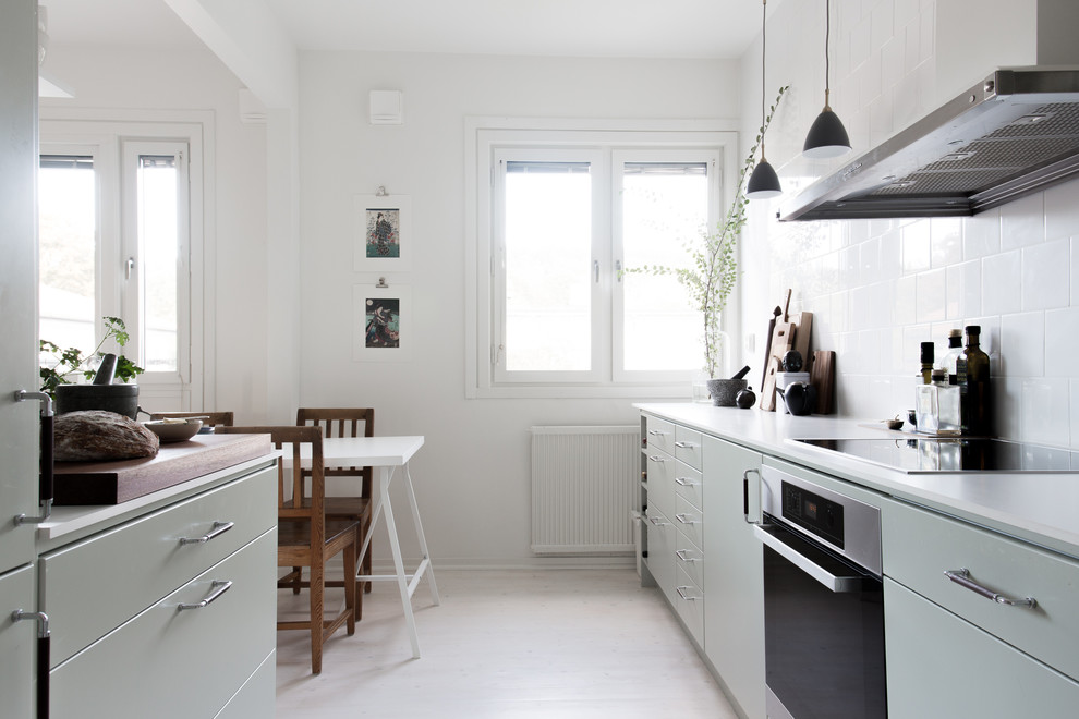 Esempio di una cucina scandinava di medie dimensioni con ante in stile shaker, ante verdi, paraspruzzi bianco e parquet chiaro
