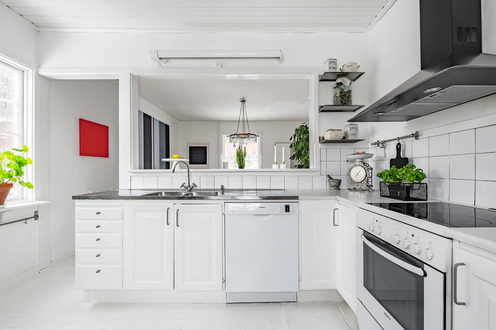 Inredning av ett minimalistiskt litet kök, med vita skåp, bänkskiva i rostfritt stål, vitt stänkskydd, stänkskydd i porslinskakel, vita vitvaror, målat trägolv och vitt golv