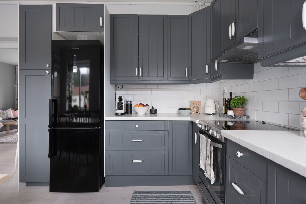 Exempel på ett mellanstort minimalistiskt kök, med en nedsänkt diskho, luckor med profilerade fronter, grå skåp, laminatbänkskiva, vitt stänkskydd, stänkskydd i keramik, svarta vitvaror, ljust trägolv och vitt golv