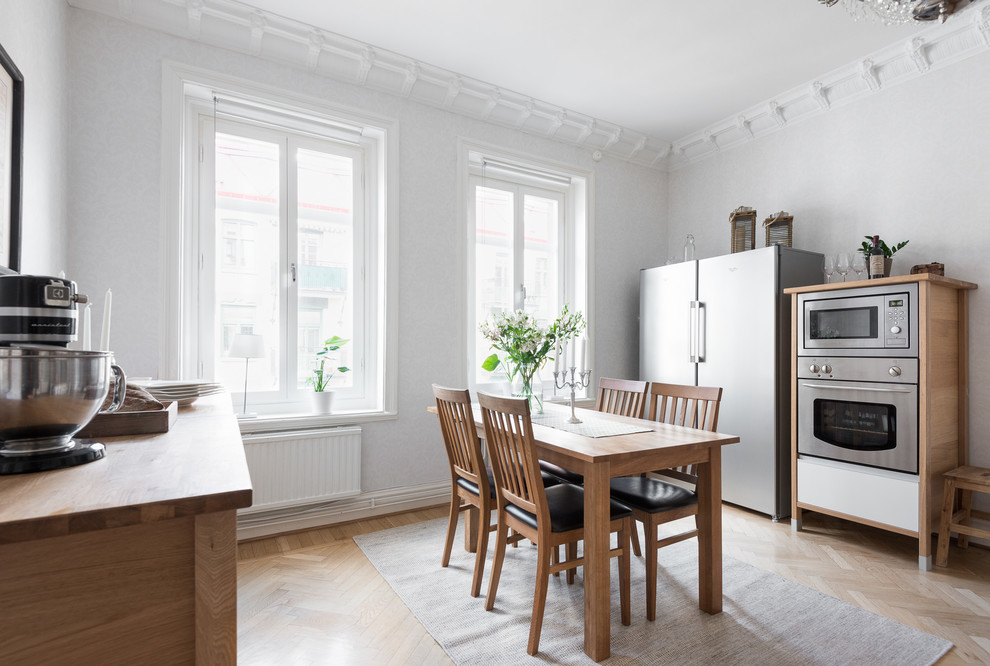 ヨーテボリにある中くらいな北欧スタイルのおしゃれなキッチン (ドロップインシンク、オープンシェルフ、木材カウンター、白いキッチンパネル、磁器タイルのキッチンパネル、無垢フローリング) の写真