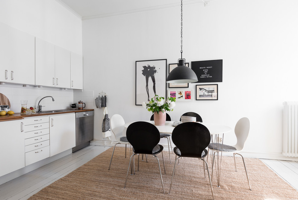 Idéer för ett mellanstort minimalistiskt linjärt kök och matrum, med en nedsänkt diskho, släta luckor, träbänkskiva, vitt stänkskydd, glaspanel som stänkskydd, rostfria vitvaror, målat trägolv och grått golv