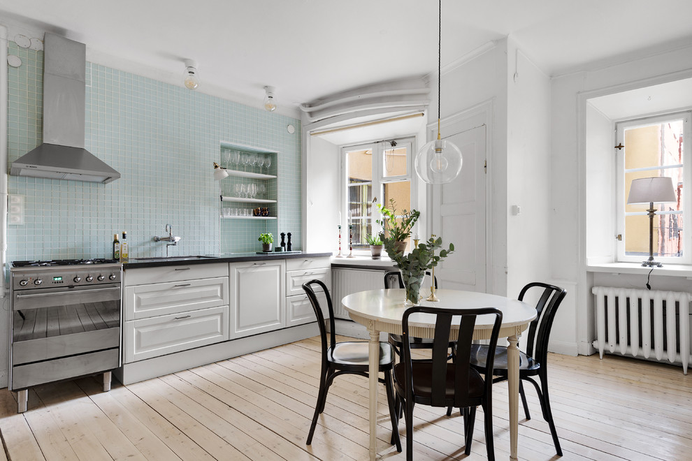 Inspiration för ett stort skandinaviskt svart svart kök och matrum, med vita skåp, blått stänkskydd, stänkskydd i glaskakel, ljust trägolv, beiget golv, en undermonterad diskho, luckor med upphöjd panel och rostfria vitvaror